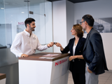 A couple handing over keys to a Nissan Service Advisor